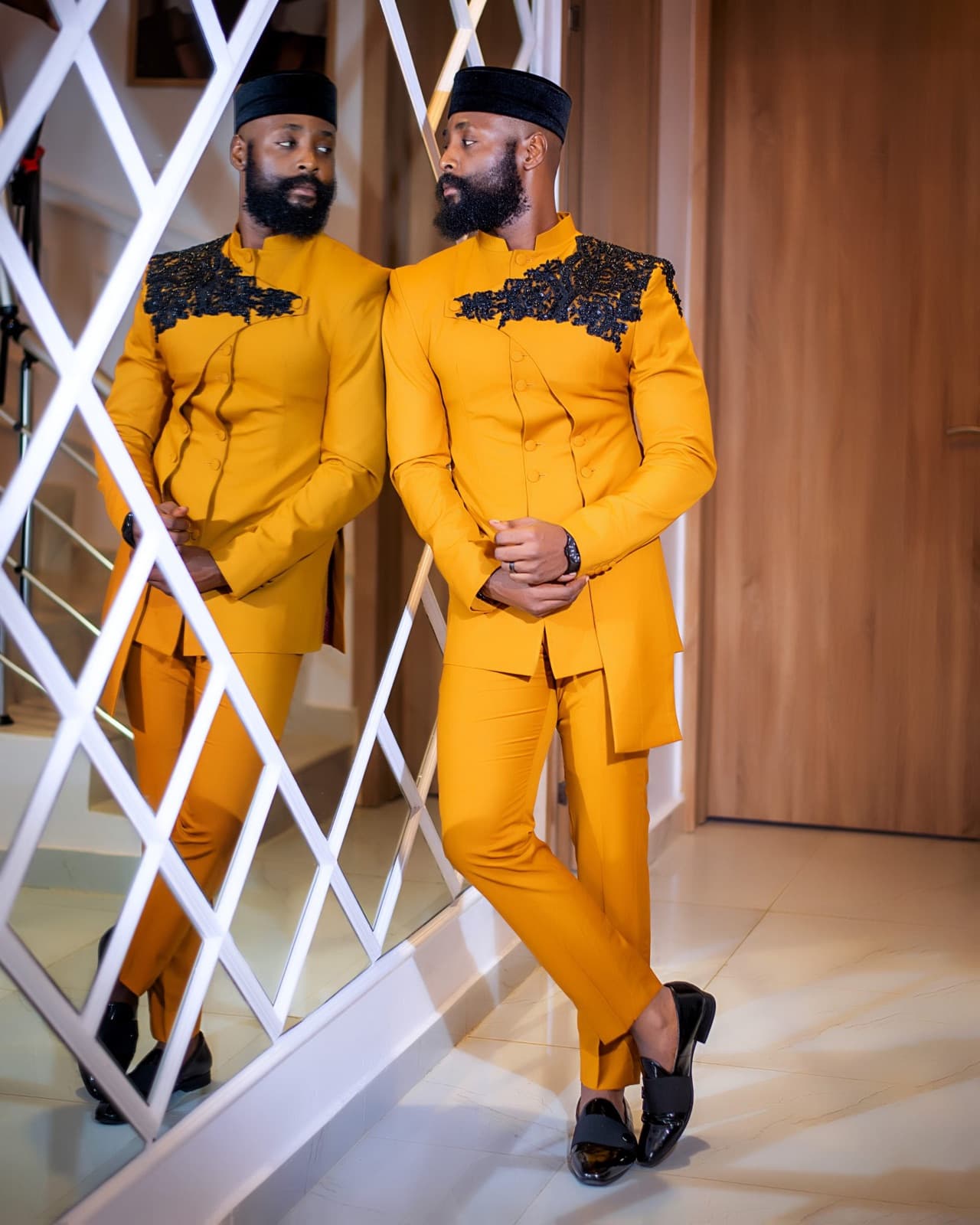 Gold safari suit with black lace detailing, photographed by a mirrored screen.